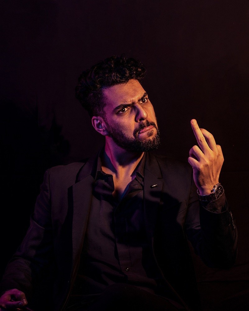 A man looking disgruntled giving the middle finger and having a very annoyed expression on his face