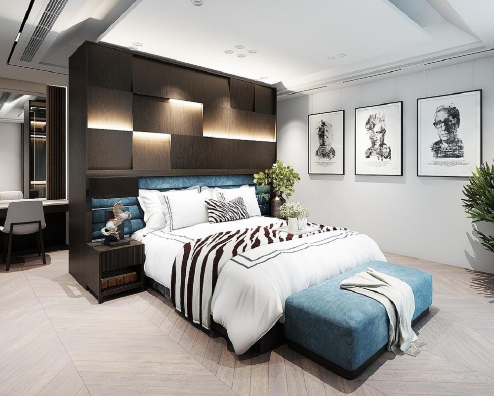 A large bed with white pillows, zebra print duvet, and blue accents sits against a dark brown shelf wall. The floor and walls are white with black and white pictures of famous actors on the wall