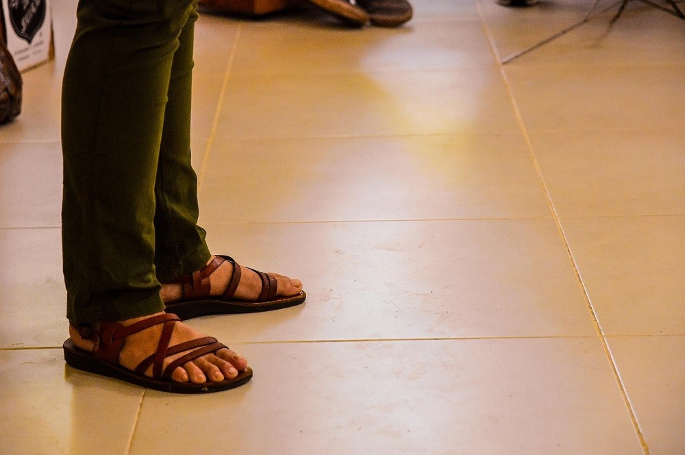 Someone is wearing open-toed sandals with dress pants. This is a major style clash and looks bad no matter who wears this combination