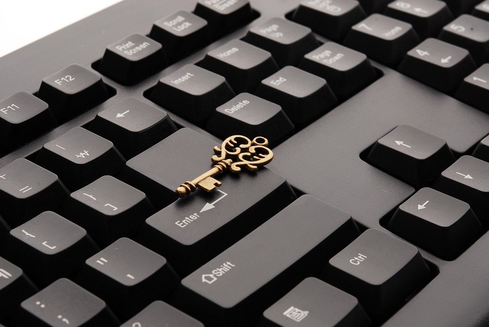 A skeleton key sits on top of the enter button on a keyboard