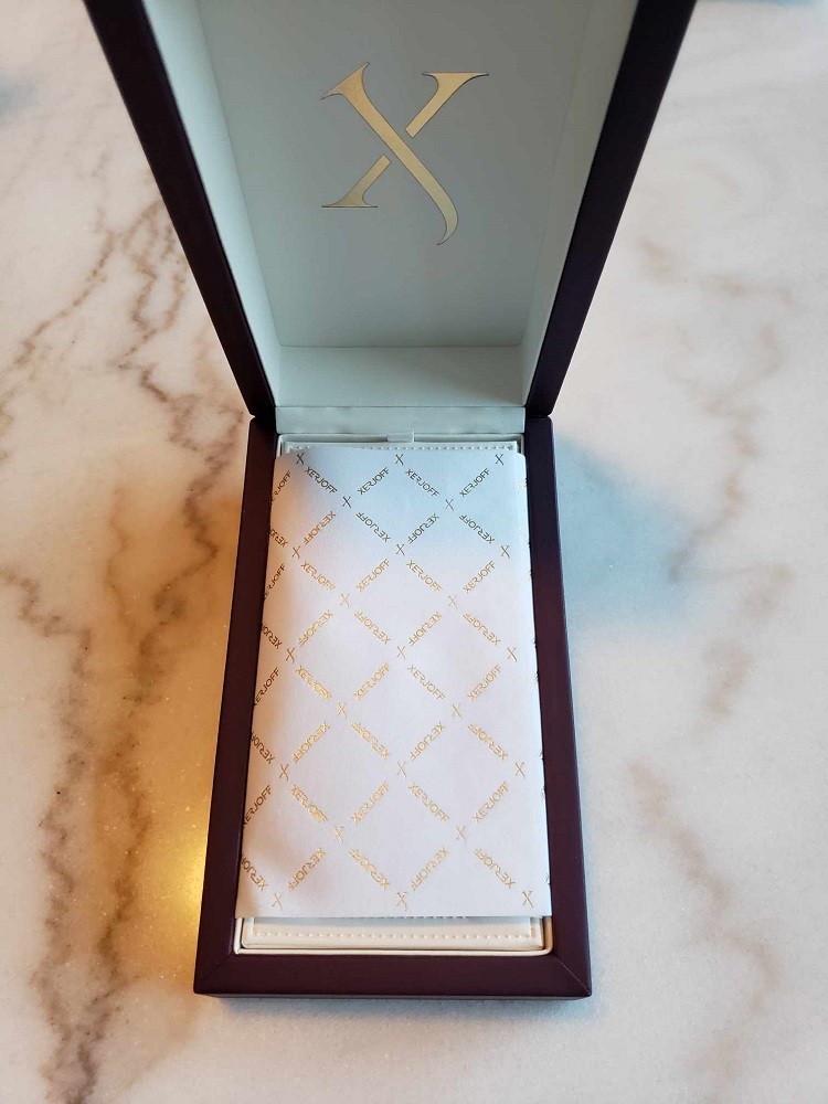 The inside of the presentation box for the cologne Don by Xerjoff features a delicate thin paper with Xerjoff branding and logos on it