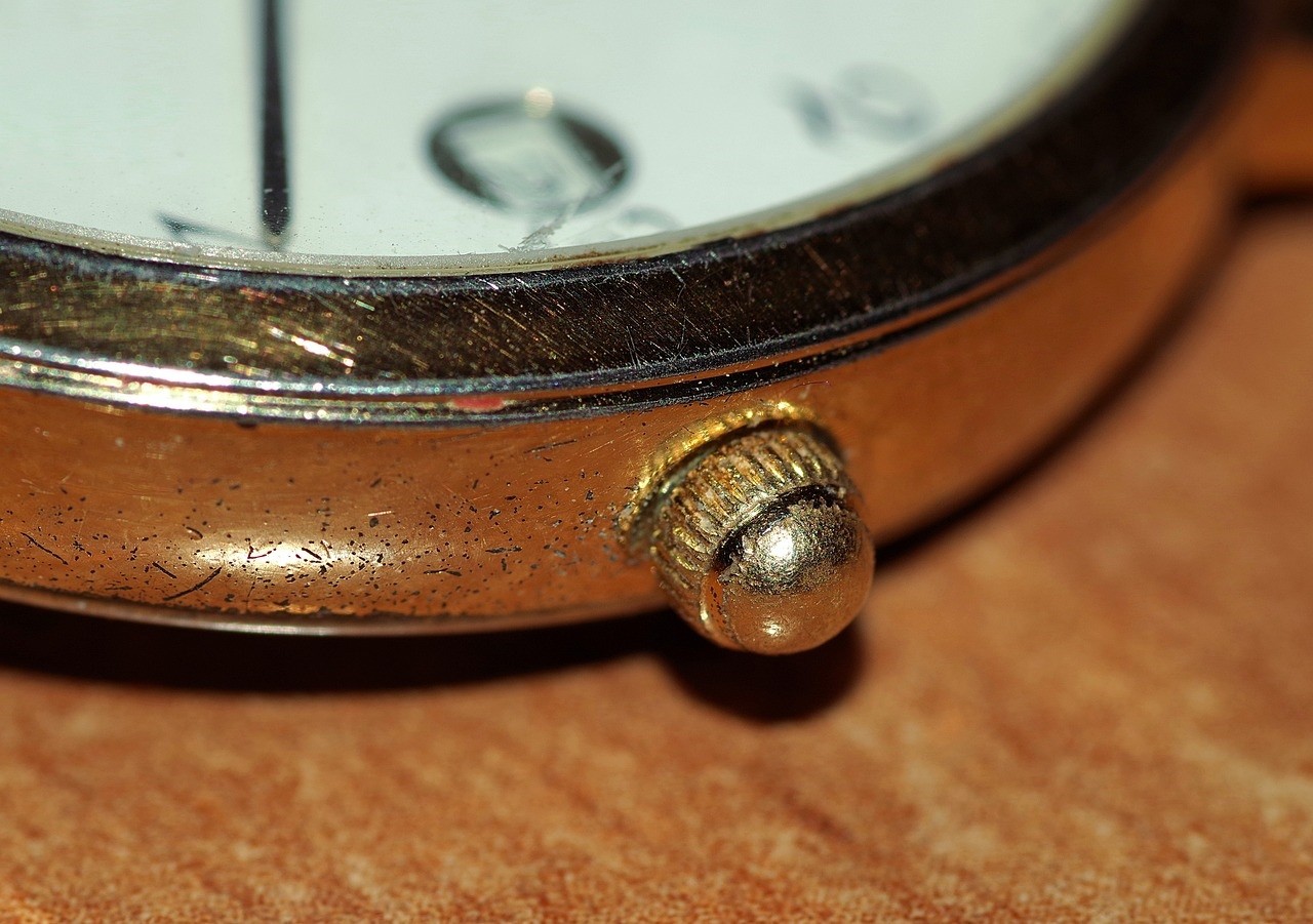 A small gold watch crown is still attached to the watch. It looks worn out and the colour is starting to fade