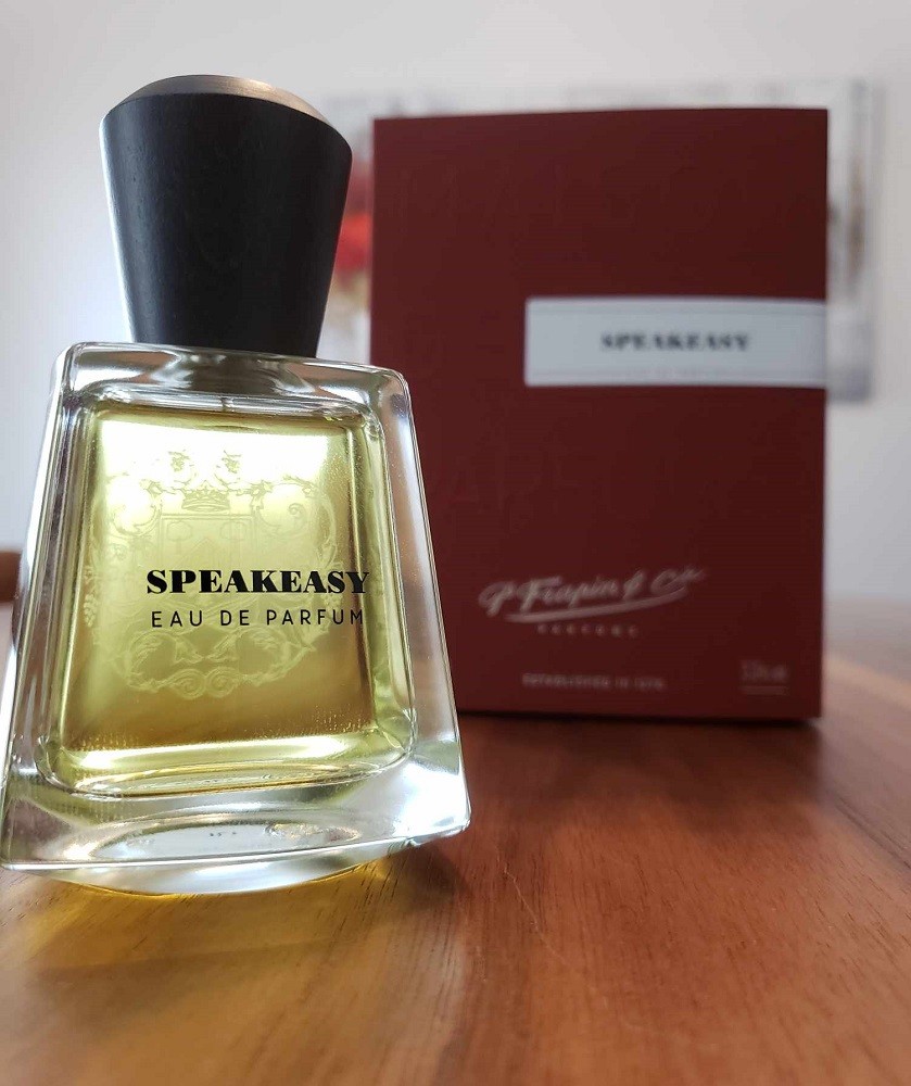 Speakeasy comes in a short trapezoid-like bottle. The cap is black. The red box it comes in sits behind the bottle