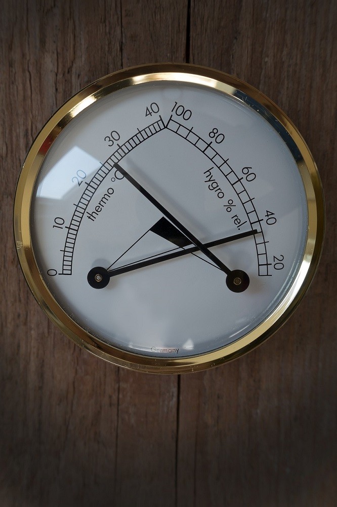 An analog cigar hygrometer showing the relative humidity and temperature