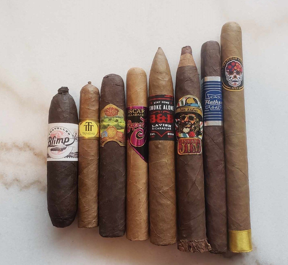 Cigars of varying sizes, colours, and bands are lined up side by side