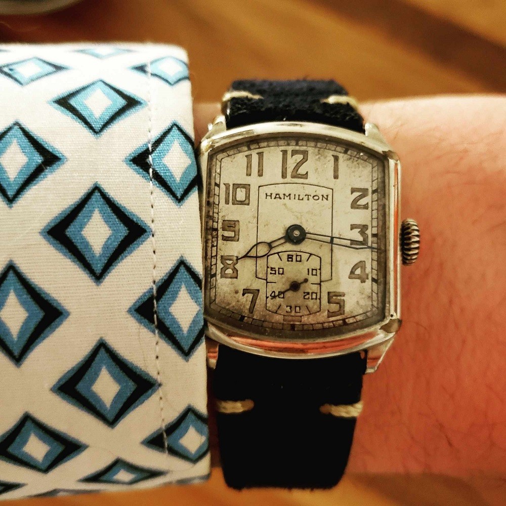 A square shaped vintage Hamilton watch from the 1920s shows signs of patina on the dial. Parts of the dial are turning brown from UV rays from the sun