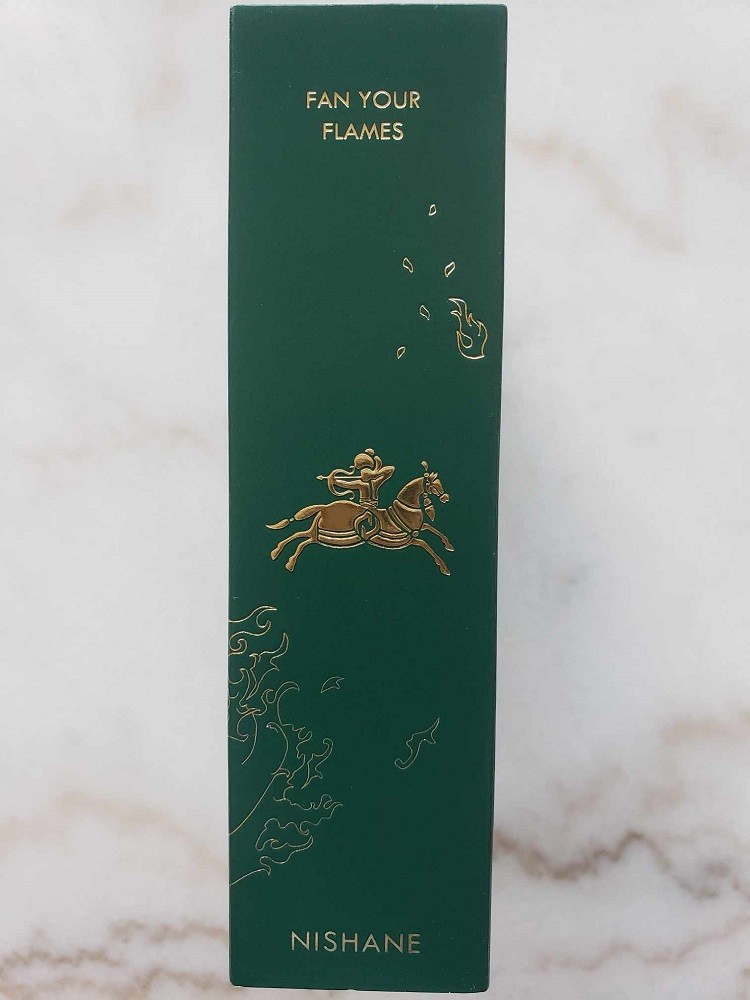 The side of the Fan Your Flames box features a man riding a horse in full stride. The box is dark green and the man and horse are gold