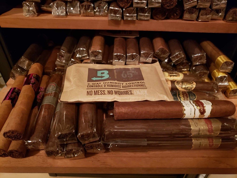 A Boveda pack sits on top of numerous cigars inside a cigar humidor