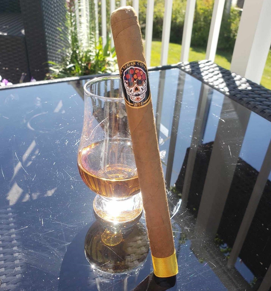 The Cha Cha Sugar 2023 Exclusive cigar is light brown in colour and features a band with a sugar skull on it