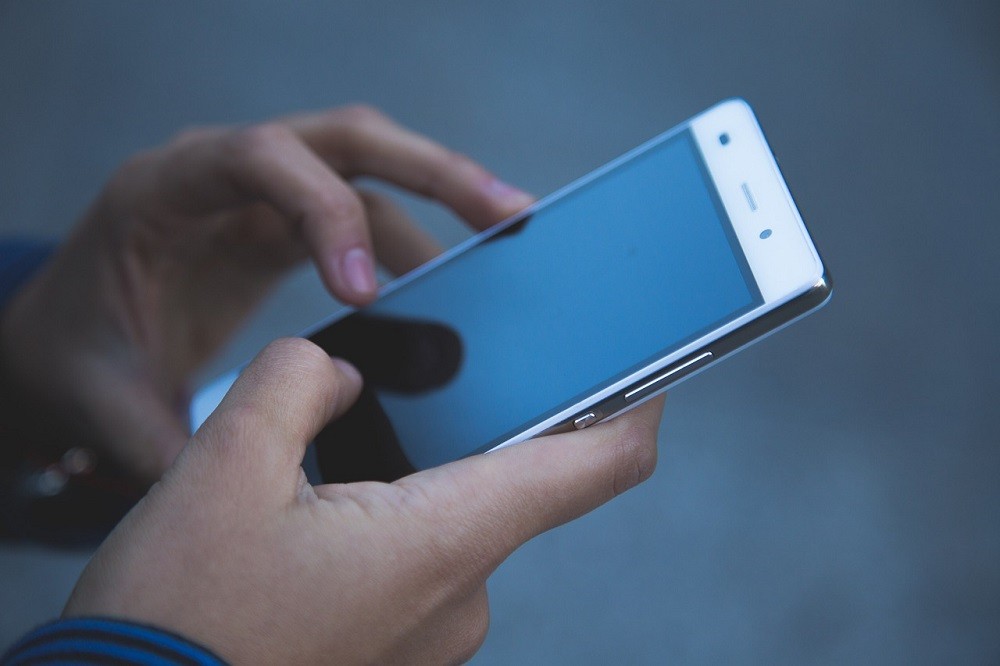 Someone is texting on their smartphone. The screen shows a conversation with their friend and where they want to meet later