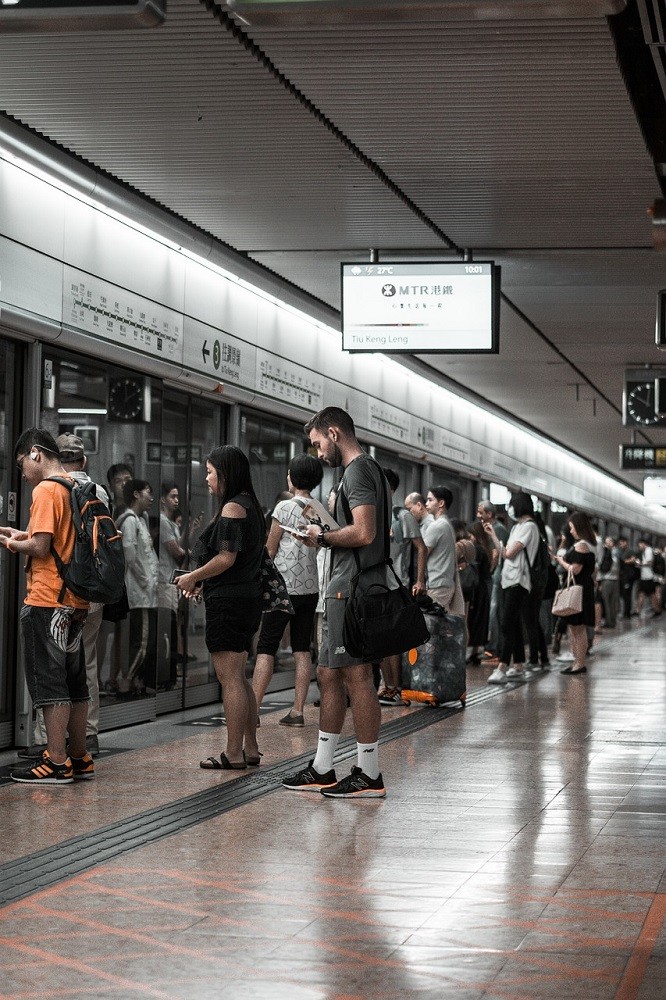 A line of people are trying to get on a train while people are trying to get off of the train at the same time