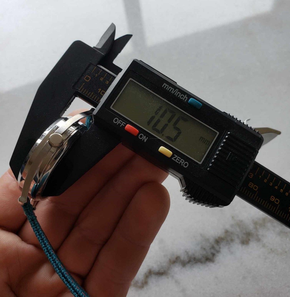 The Mispoes watch by Mr Jones watches measures 10.5mm thick. A caliper is used to verify and display the accurate measurement