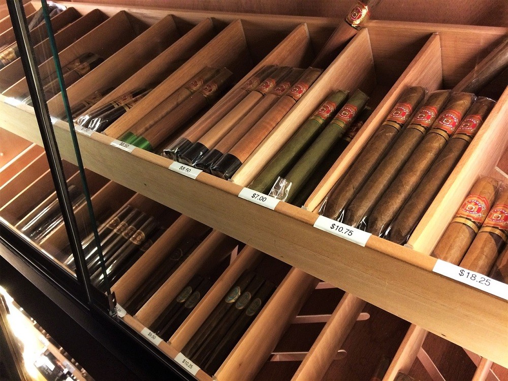 Boxes of cigars are displayed behind a glass door at a cigar shop