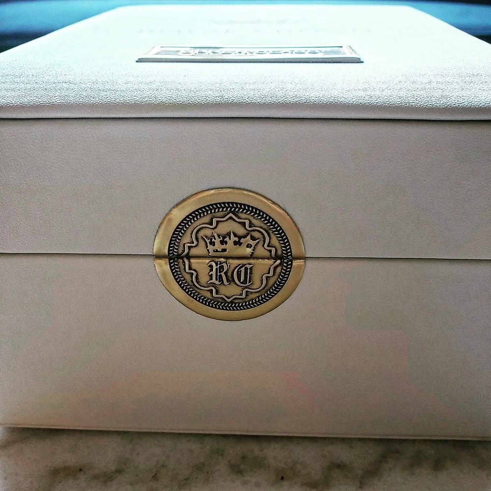 A gold seal keeps the white box of Upper Class by Royal Crown closed during shipping. This seal is often used on luxury goods
