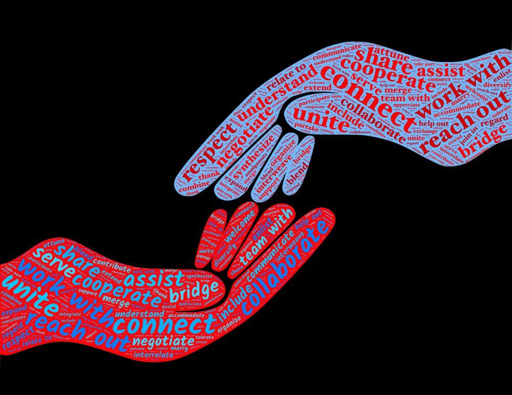 Two hands are reaching out to each other. Both hands have positive words written on them like 