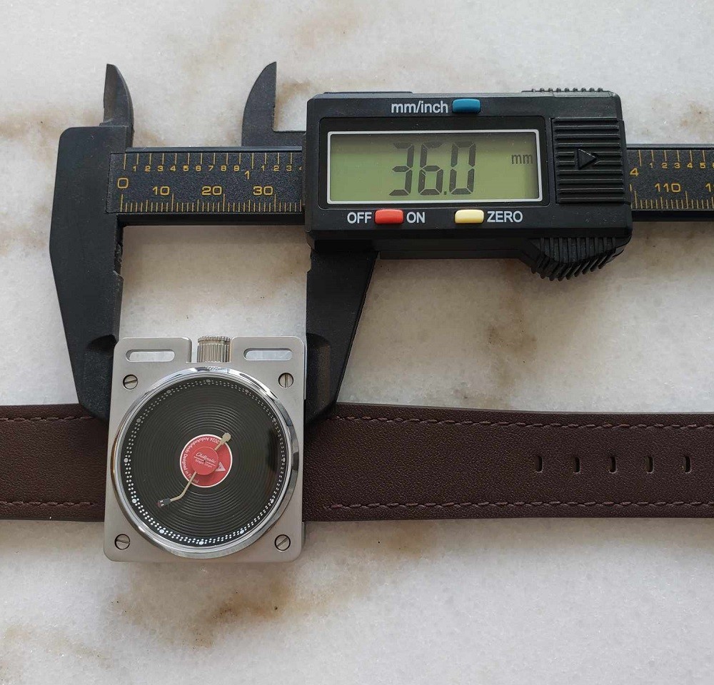 The length of the Vinyl Record Watch by AndoAndoAndo is 36mm. A caliper verifies this measurement with a digital display