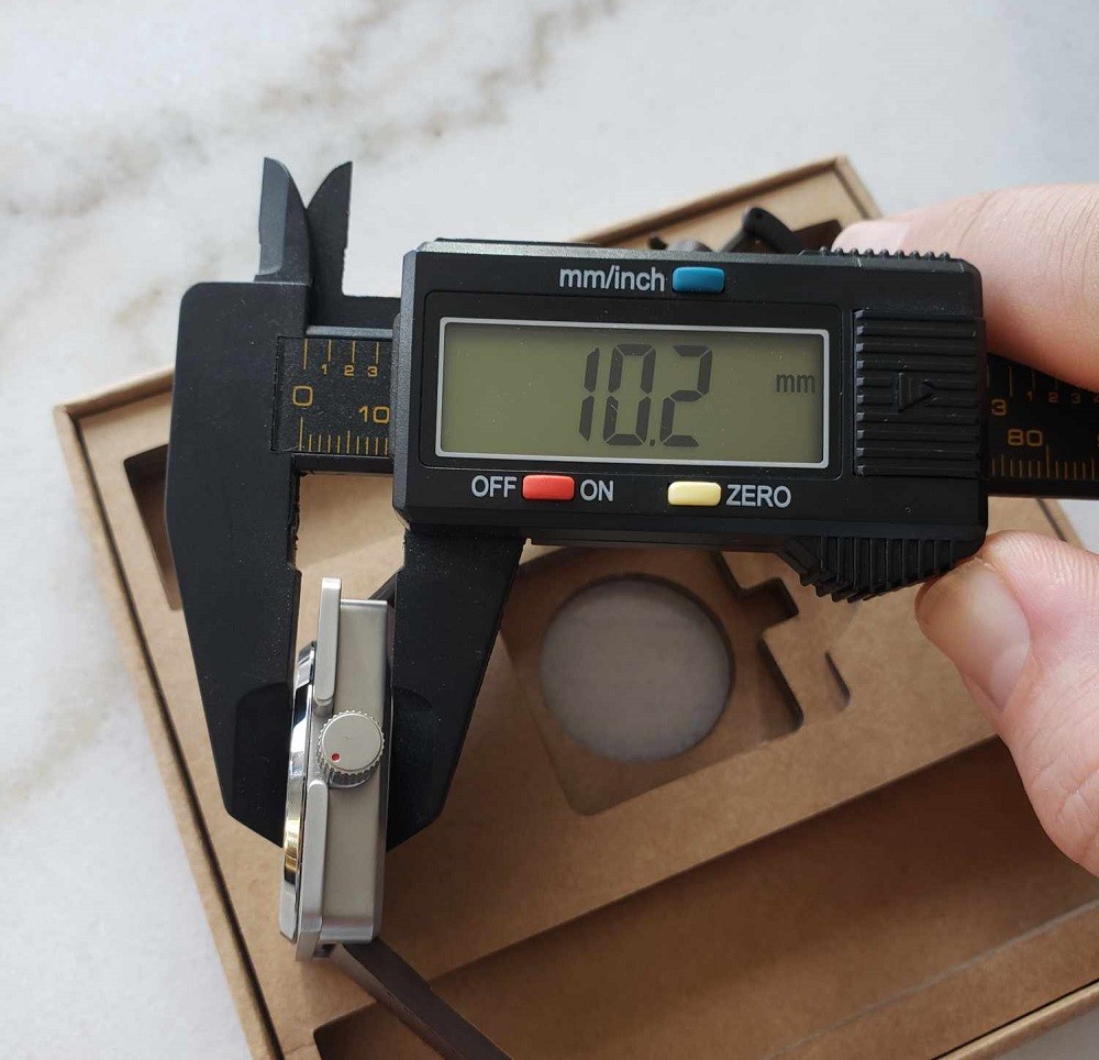 The thickness of the Vinyl Record Watch by AndoAndoAndo is 10.2mm. A caliper verifies this measurement with a digital display
