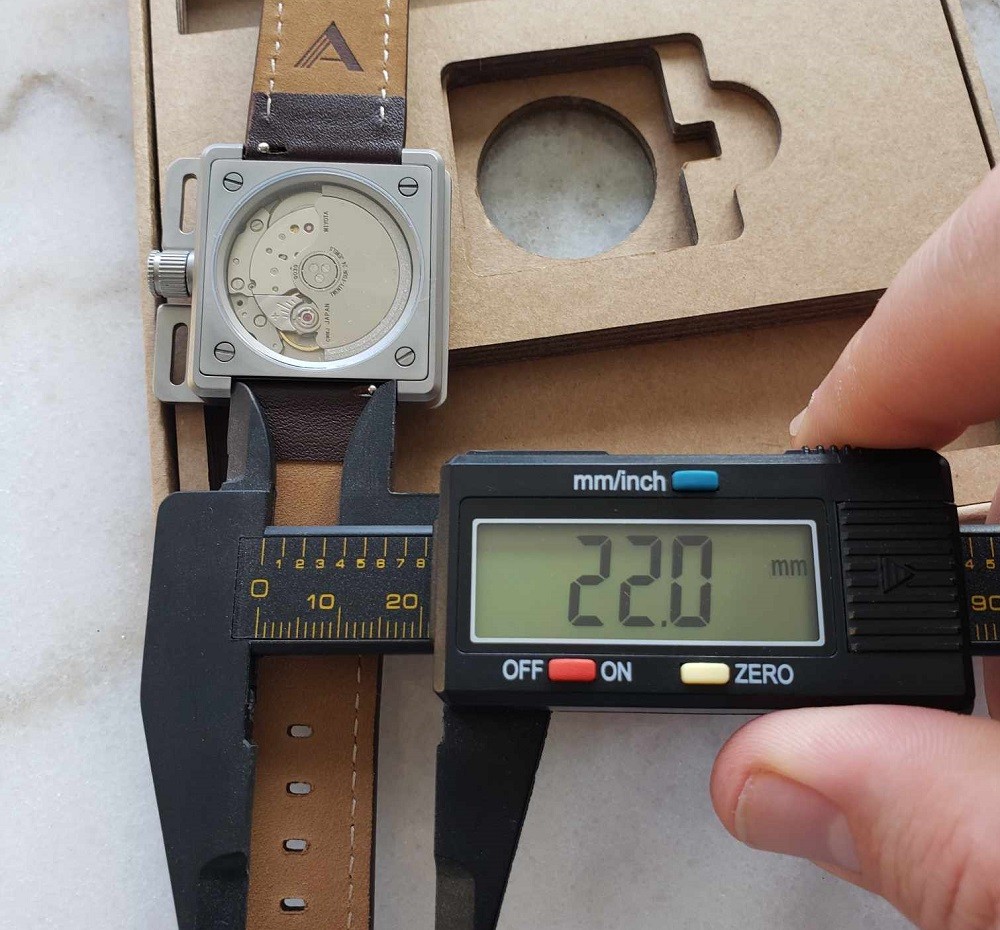 The lug to lug measurement of the Vinyl Record Watch by AndoAndoAndo is 22mm wide. A caliper verifies this measurement with a digital display