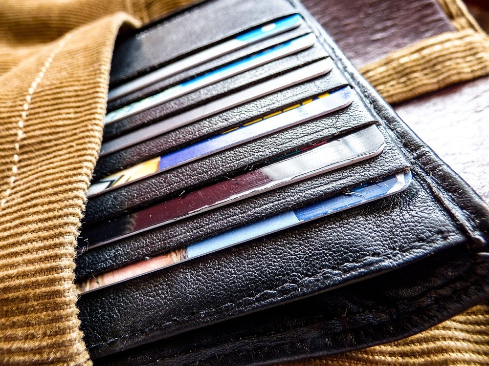 A wallet with numerous cards sits on a table