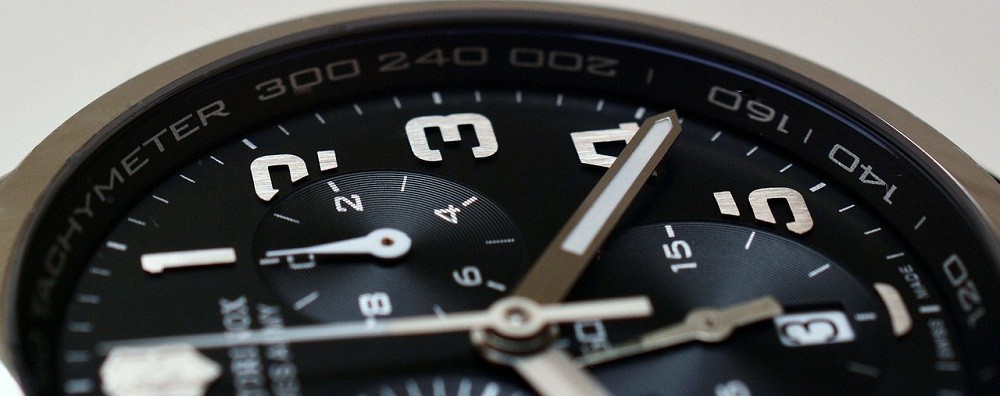 A close-up of a watch shows the hour and minute hand. The watch also has a chronograph function, but it isn't being used in the picture
