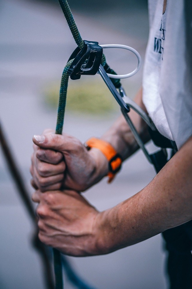A man about to rock climb is checking his safety harness