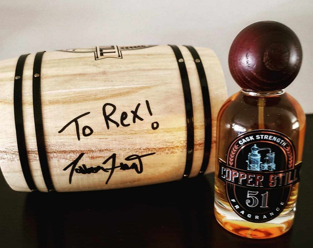 A closeup of the autograph by the owner of Copper Still Fragrance on the side of the miniature barrel box the fragrance comes in