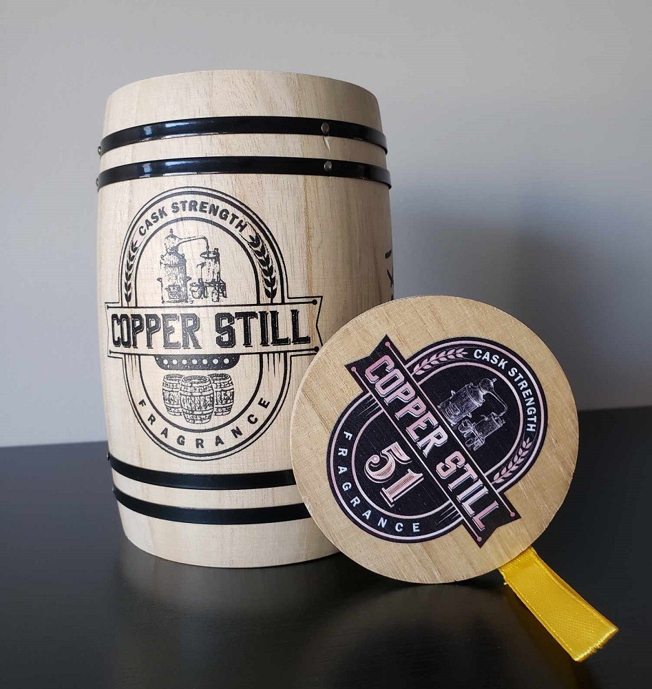 A closeup of the miniature barrel the fragrance 51 by Copper Still Fragrance comes in. It looks like a small version of an actual whiskey barrel