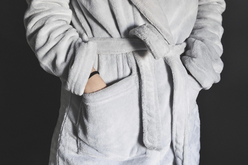 A man is wearing a white robe. It looks very comfy