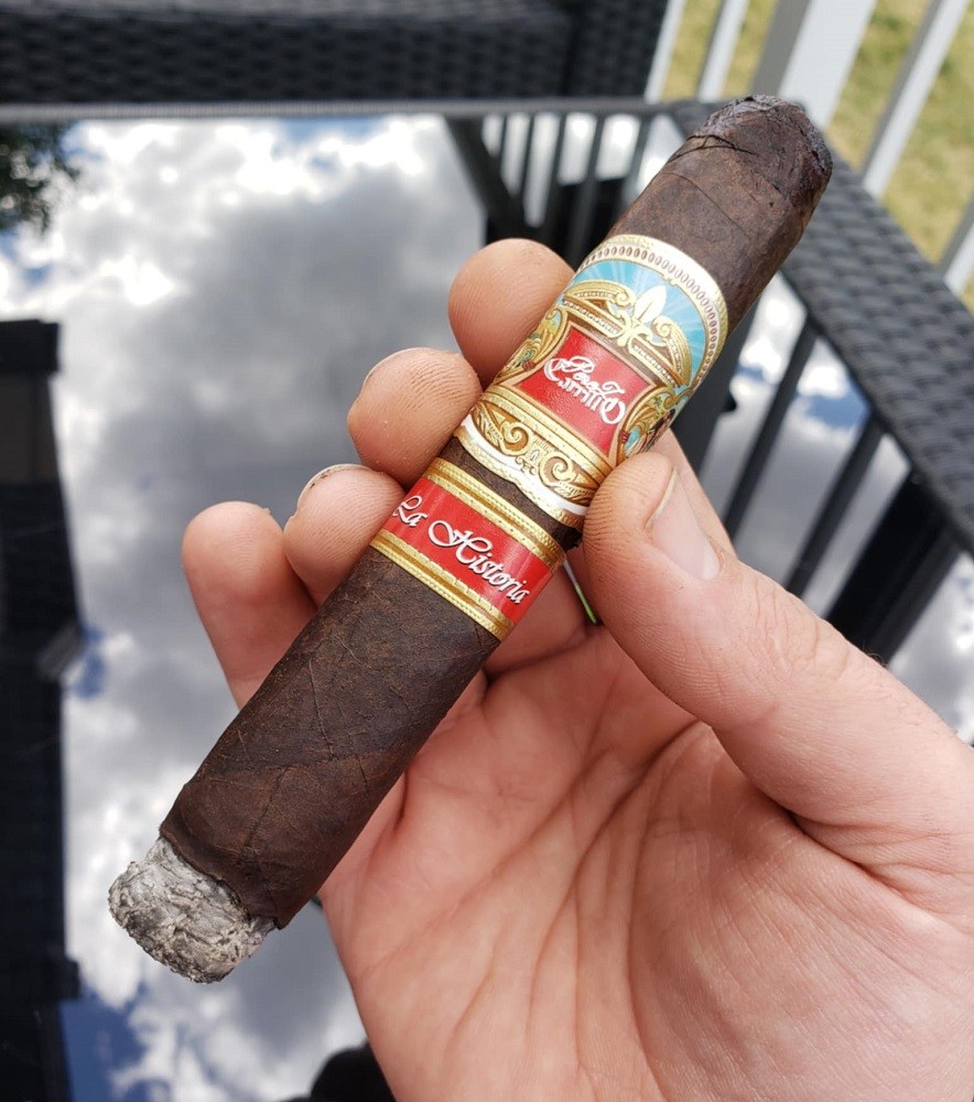 The La Historia by EP Carrillo cigar is lit and holds about half an inch of ash on the end