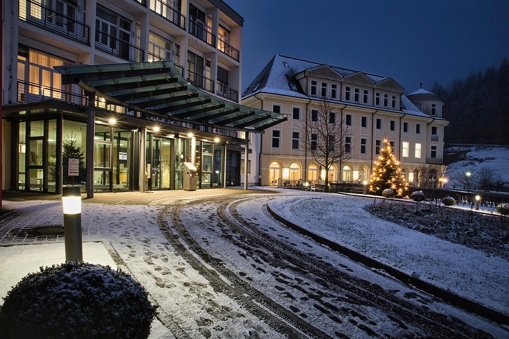 A view from the front of a fancy hotel during winter. The drive lane is covered with snow