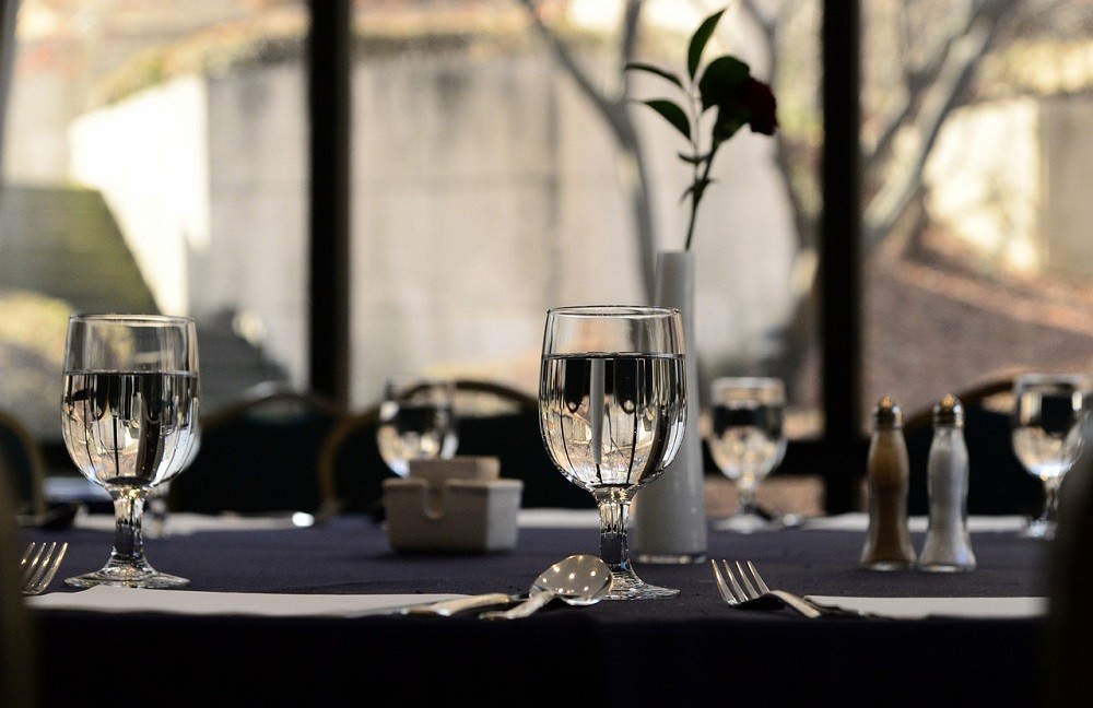 A fancy table setup is shown complete with fragile glassware, silverware, and cloth napkins