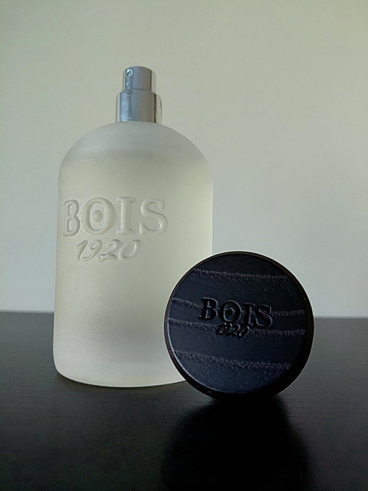 The powdery bottle of Classic 1920 by Bois 1920 shows the wood grain-textured black cap beside the bottle