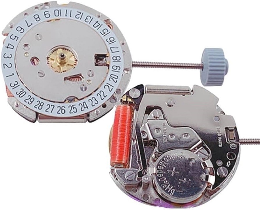 A movement from a quartz watch shows the battery, piece of quartz, and date wheel
