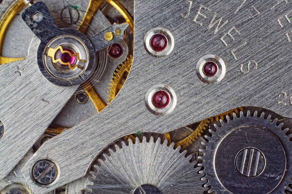 A close-up look at a watch movement with jewels, gears, screws, and springs