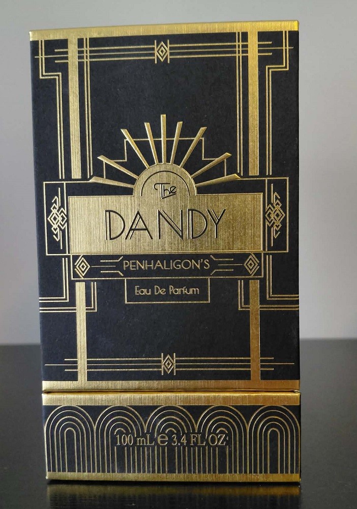 A rectangular black box with gold art-deco inspired patterns