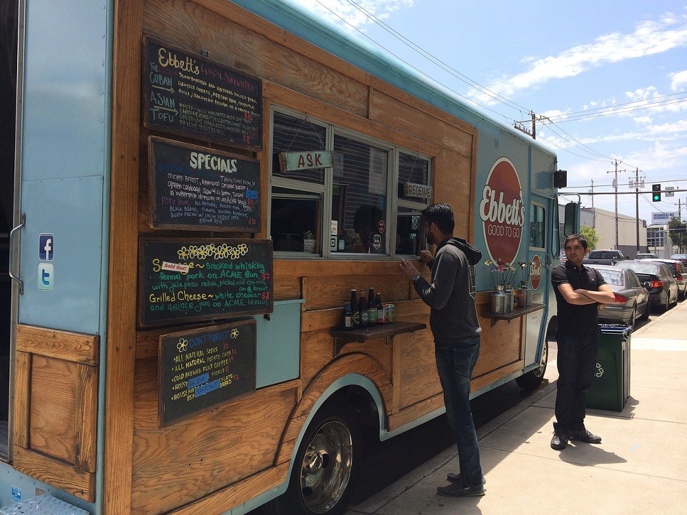 A man is ordering a meal from a food truck