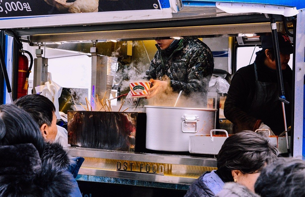 A food truck prepares food for a large group of people