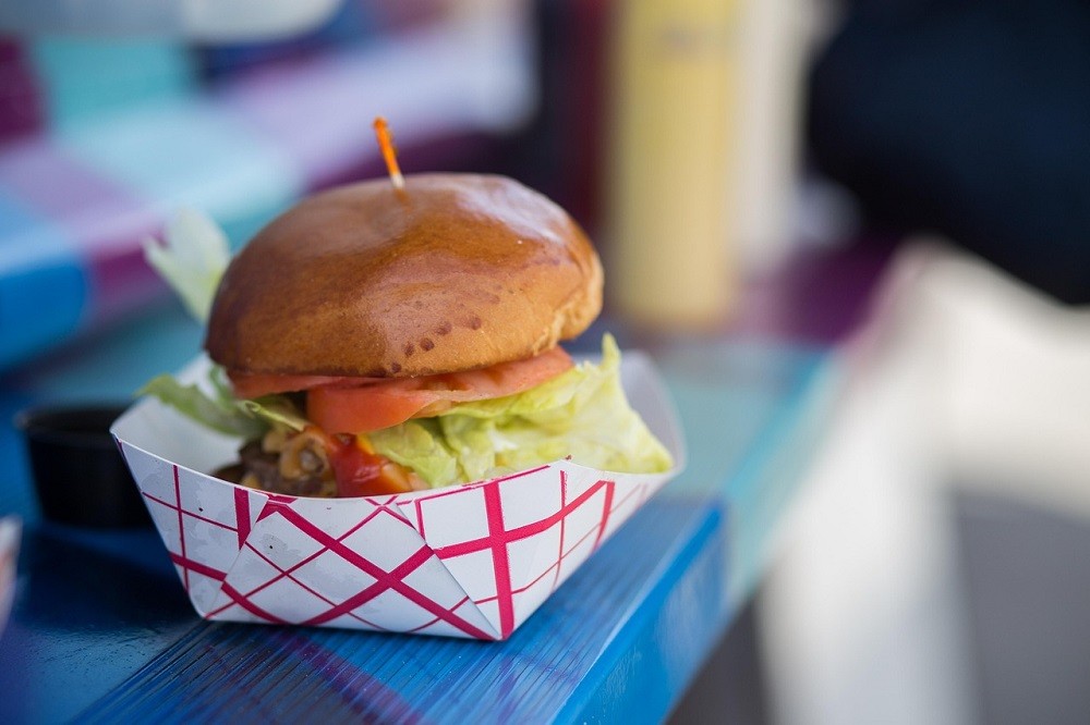A burger made in a food truck is ready for the customer