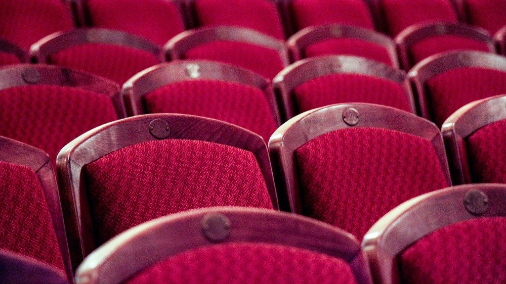 Several rows of red movie theatre chairs