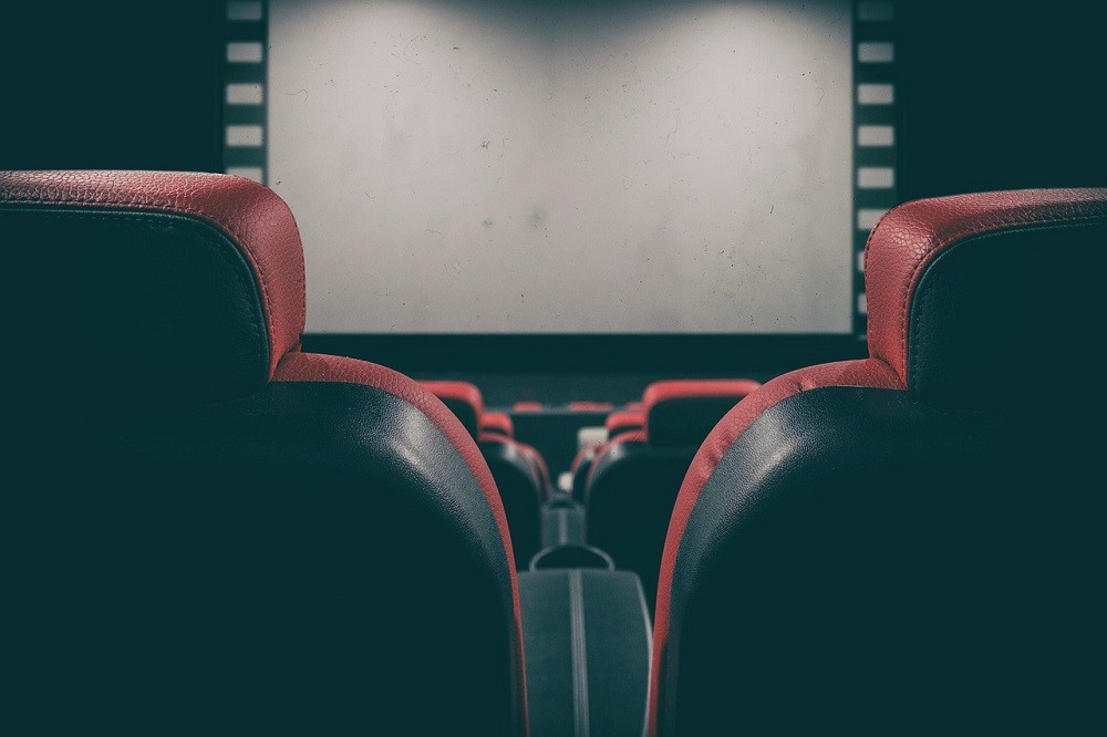 A view of a movie screen from between two seats