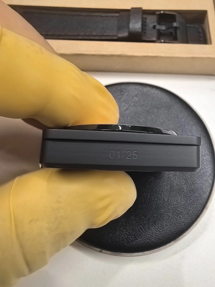 A matte black watch case shows the number 01 of 25 etched into the side