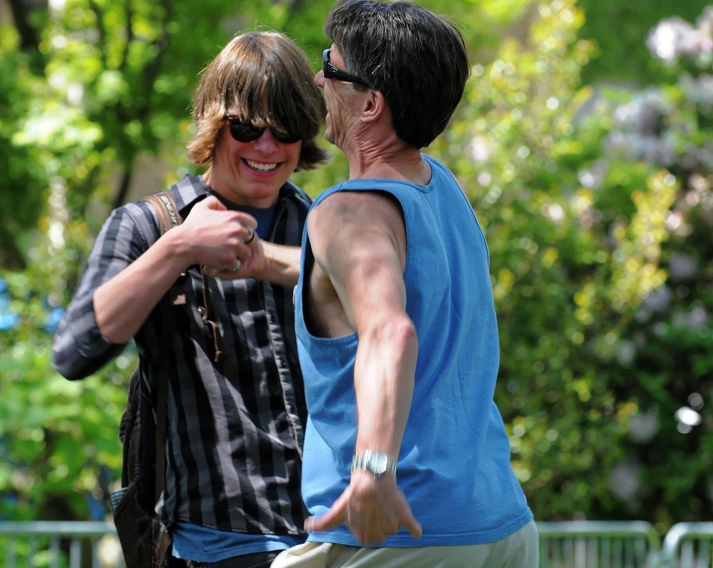 Two men are greeting each other with a fist bump