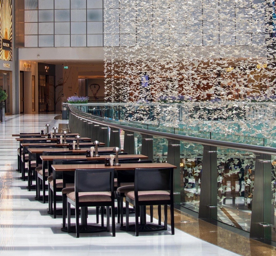 Several wooden tables in a mall food court