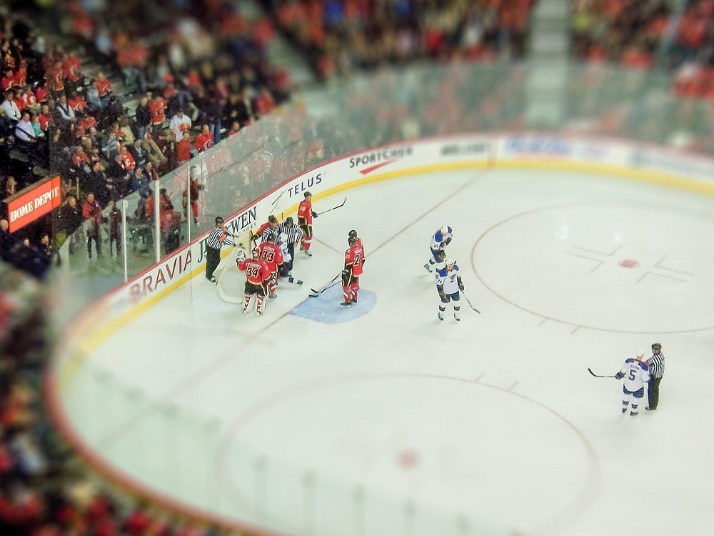 A hockey game with players surrounding a goalie