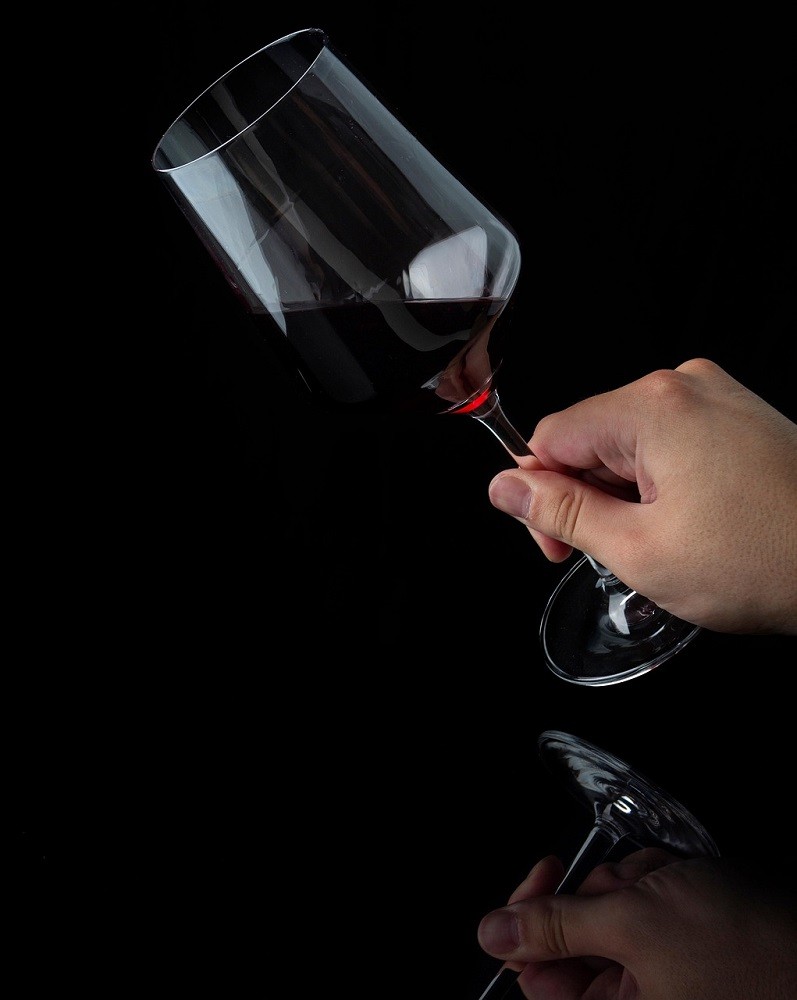 Someone is swirling a glass of red wine