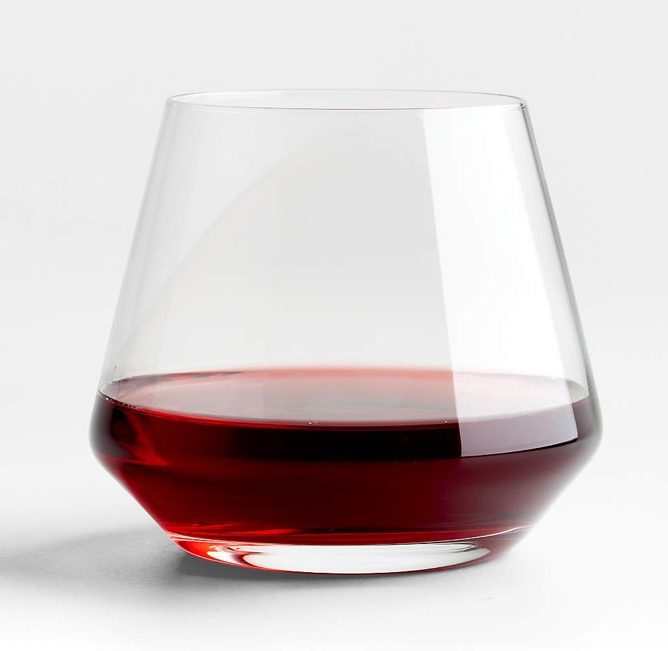 A stemless wine glass has some red wine in it
