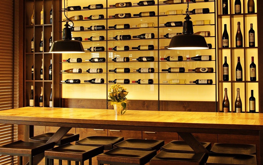 A wine wall at a restaurant features dozens of bottles displayed on their sides with the labels facing out