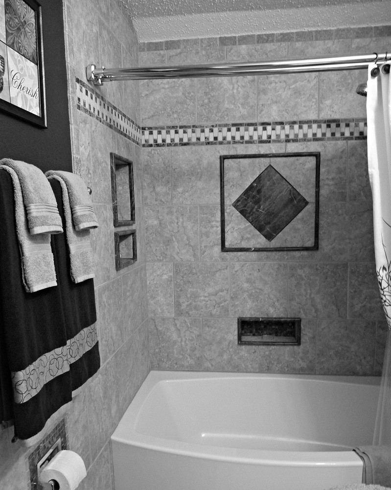 A black and white photograph of a bathroom featuring decorative towels on a towel rack