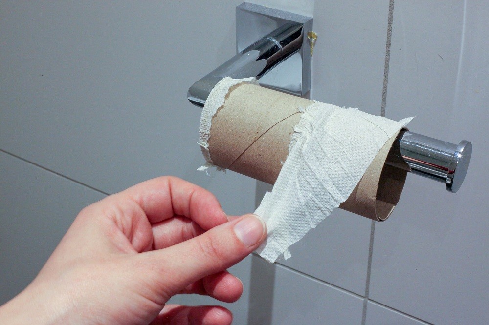 Someone is peeling the last piece of toilet paper off of the roll