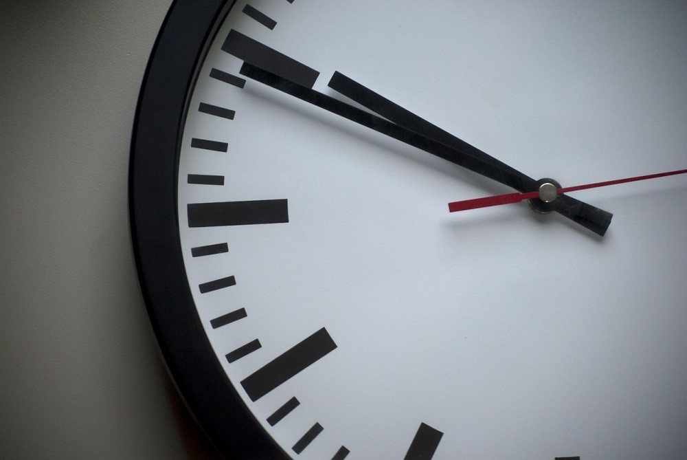 A white clock face with black hands and indices